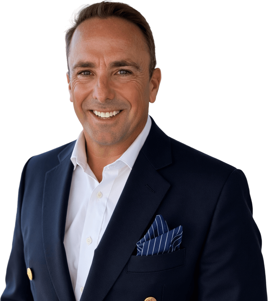 Peter Damato in a navy blazer and white open-collar shirt, smiling